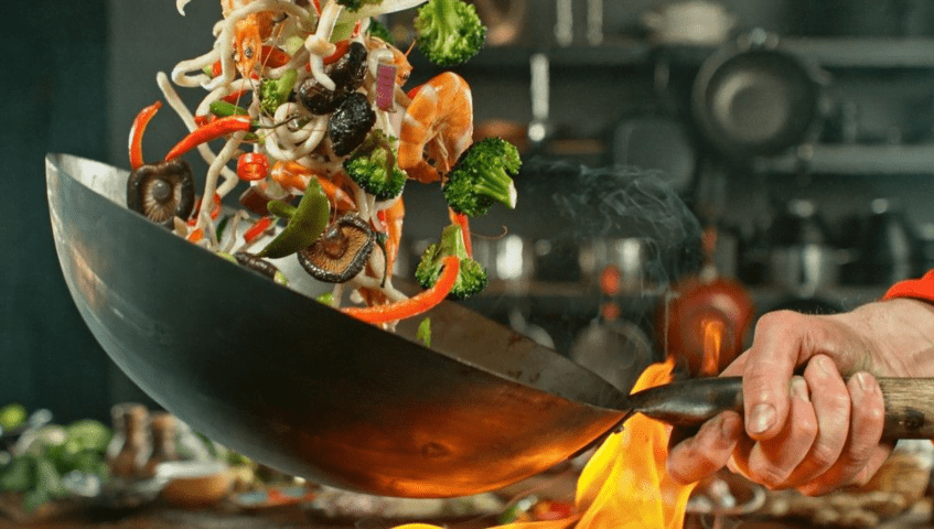 Wok de cocina con alimentos de aprovechamiento, evitando el desperdicio alimentario en restaurantes